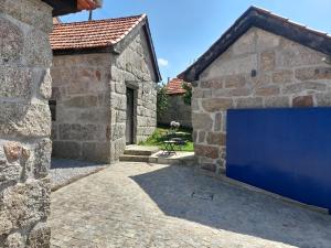 una puerta de garaje azul en un edificio de piedra en Casas do Arrabalde, en Amarante