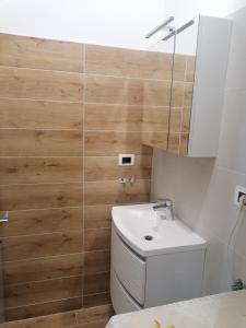 a bathroom with a white toilet and a sink at Apartments Vellico in Bale