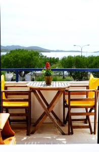 a wooden table with a potted plant on a balcony at Galazio Limani - Rooms to let in Moúdhros