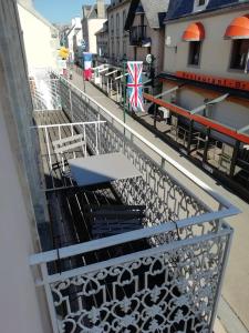 - une vue sur un balcon avec un banc dans un bâtiment dans l'établissement Le DINGSON, à Arromanches-les-Bains