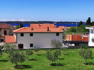 biały budynek z czerwonym dachem na dziedzińcu w obiekcie Apartment Lighthouse n3 w Fažanie +16 zdjęć