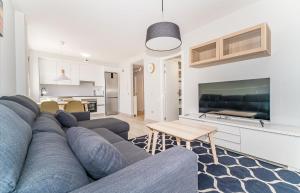 a living room with a blue couch and a kitchen at Tejita beach , The beach dream flats in Granadilla de Abona
