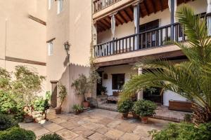 a courtyard of a building with plants and a balcony at Casa del Aljibe in Granada