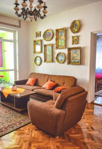 una sala de estar con sofá y muchos platos en la pared en Apartmani Jelenković en Negotin