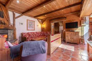 a living room with a couch and a television at Chalet Quatre Saisons in Saint-Gervais-les-Bains