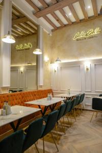 un restaurante con mesas y sillas y un cartel en la pared en Calla Bella Rooms & Snack Bar en Skopie