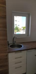 Un baño con lavabo y ventana. en Sunset Relax Porch, en Lagos
