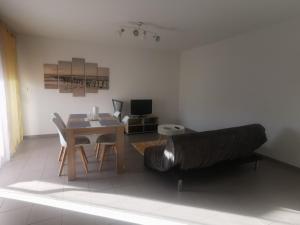 a living room with a table and a couch at Appartement T2 accessible PMR avec terrasse et garage in Onet le Château