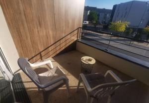 2 sillas y una mesa en el balcón en Appartement T2 accessible PMR avec terrasse et garage en Onet le Château