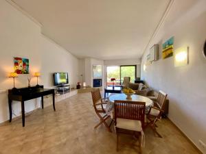- un salon avec une table, des chaises et un piano dans l'établissement Victory Village Quinta do Lago - Spacious 2 Bed / 3 Bath Apartment, à Almancil