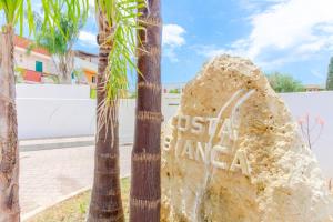 un rocher devant un palmier dans l'établissement Residence Costa Bianca, à Gallipoli
