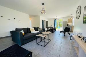 a living room with a couch and a table at Recent house in a hamlet near the Cher in Athée-sur-Cher