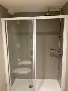 La salle de bains est pourvue d'une cabine de douche en verre et de toilettes. dans l'établissement Fly Bike Hotel, à Trente