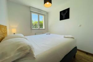 a bedroom with a large white bed with a window at Recent house in a hamlet near the Cher in Athée-sur-Cher