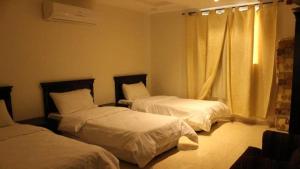 a hotel room with two beds and a window at كريستال الذهبية in Taif