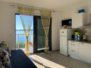 a kitchen with a large window with a view of the ocean at Villa Riki in Živogošće