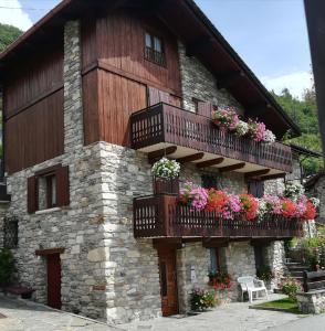 a building with flower boxes and balconies on it at Appartamento con vista chez Mary in Roisan