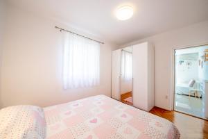 a bedroom with a bed with a pink bedspread at Bungalows Ivan (3757) in Bol