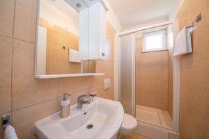 a bathroom with a sink and a toilet and a mirror at Bungalows Ivan (3757) in Bol +48 photos