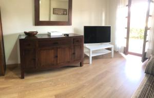 a living room with a tv and a wooden dresser at playa ribadesella kety in Ribadesella