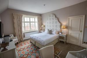 a bedroom with a bed and a large window at The George Hotel and Beach Club in Yarmouth