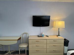 Habitación con escritorio y TV en la pared. en Monaco Motel - Wildwood, en Wildwood