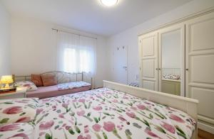 a bedroom with a bed with a floral bedspread at Apartman Slavko in Šibenik