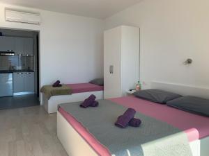 a bedroom with two beds with purple pillows on them at Villa Riki in Živogošće