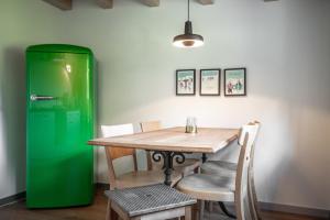 een groene koelkast naast een tafel en stoelen bij Berggasthaus Crest'ota in Lenzerheide