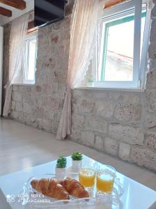 a table with a plate of croissants and orange juice at Studio Makala in Trogir +15 photos