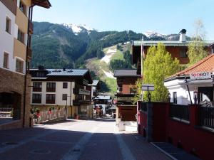 an empty street in a town with mountains in the background at Haus Bergheim in Saalbach Hinterglemm