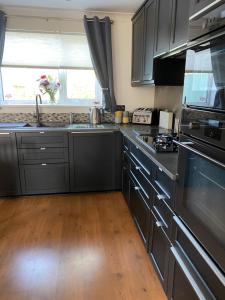 uma cozinha com electrodomésticos em aço inoxidável e piso em madeira em Craster Crew Quarters em Craster