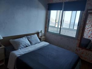 una piccola camera con letto e finestra di Apartment on the beach and ocean sounds a Fasnia