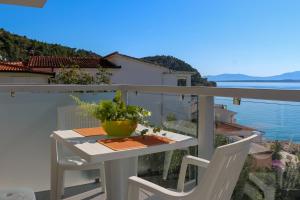 a table and chairs on a balcony with a view of the water at Villa Riki in Živogošće