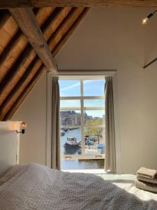 a bedroom with a large window with a view of a harbor at The Harbour Leiden in Leiden