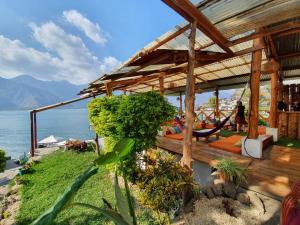 a pavilion with people sitting on it next to the water at Casa Blanca - San Pedro in San Pedro La Laguna