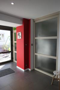 Habitación con puertas correderas de cristal y pared roja. en Au Petit Paradis en Ammerschwihr