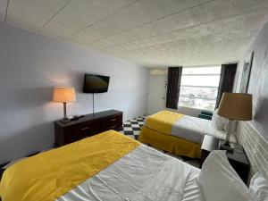 a hotel room with two beds and a tv at Monaco Motel - Wildwood in Wildwood