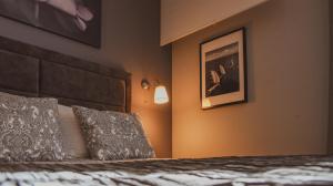 - une chambre avec un lit et une photo sur le mur dans l'établissement Apartmani Kameno Sidro, à Bilice