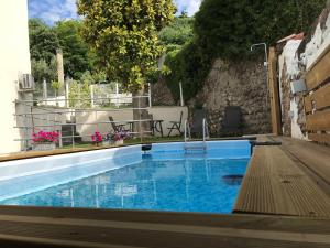 a small swimming pool with a wooden deck next to a building at Casale Luel in Valeggio sul Mincio