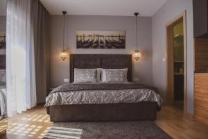 1 dormitorio con 1 cama grande y 2 almohadas en Apartmani Kameno Sidro, en Bilice