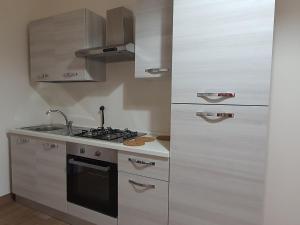 una cucina con armadietti bianchi e piano cottura di Villa Martina a Mascalucia