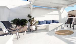 a living room with a couch and chairs on a patio at Bougainvillea Typical Town House - Private Rooftop in Mikonos
