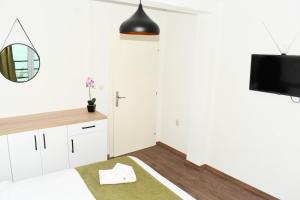 KLIO Apartments في ستروغا: غرفة نوم بيضاء مع سرير ومرآة
