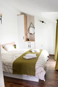 a bedroom with a bed with white sheets and a mirror at KLIO Apartments in Struga