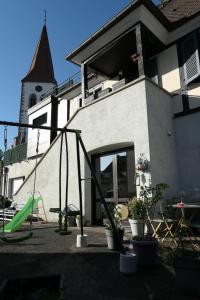 a playground in front of a building with a church at Au Petit Paradis in Ammerschwihr