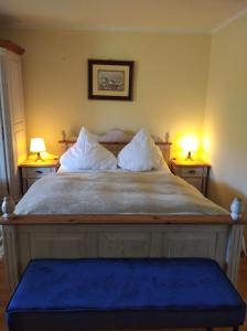 ein Schlafzimmer mit einem großen Bett mit zwei Endtischen in der Unterkunft "Aalreuse" in Heringsdorf
