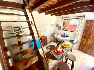 a room with a kitchen and a table with a sink at Cumelen in Jericoacoara