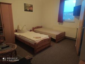 een hotelkamer met 2 bedden en een raam bij ALTE MOLKEREI Wolgast in Wolgast