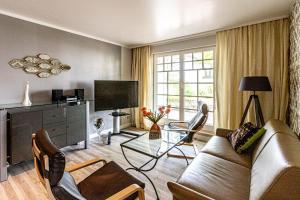 a living room with a couch and chairs and a tv at Ferienwohnungen auf Rügen in Binz